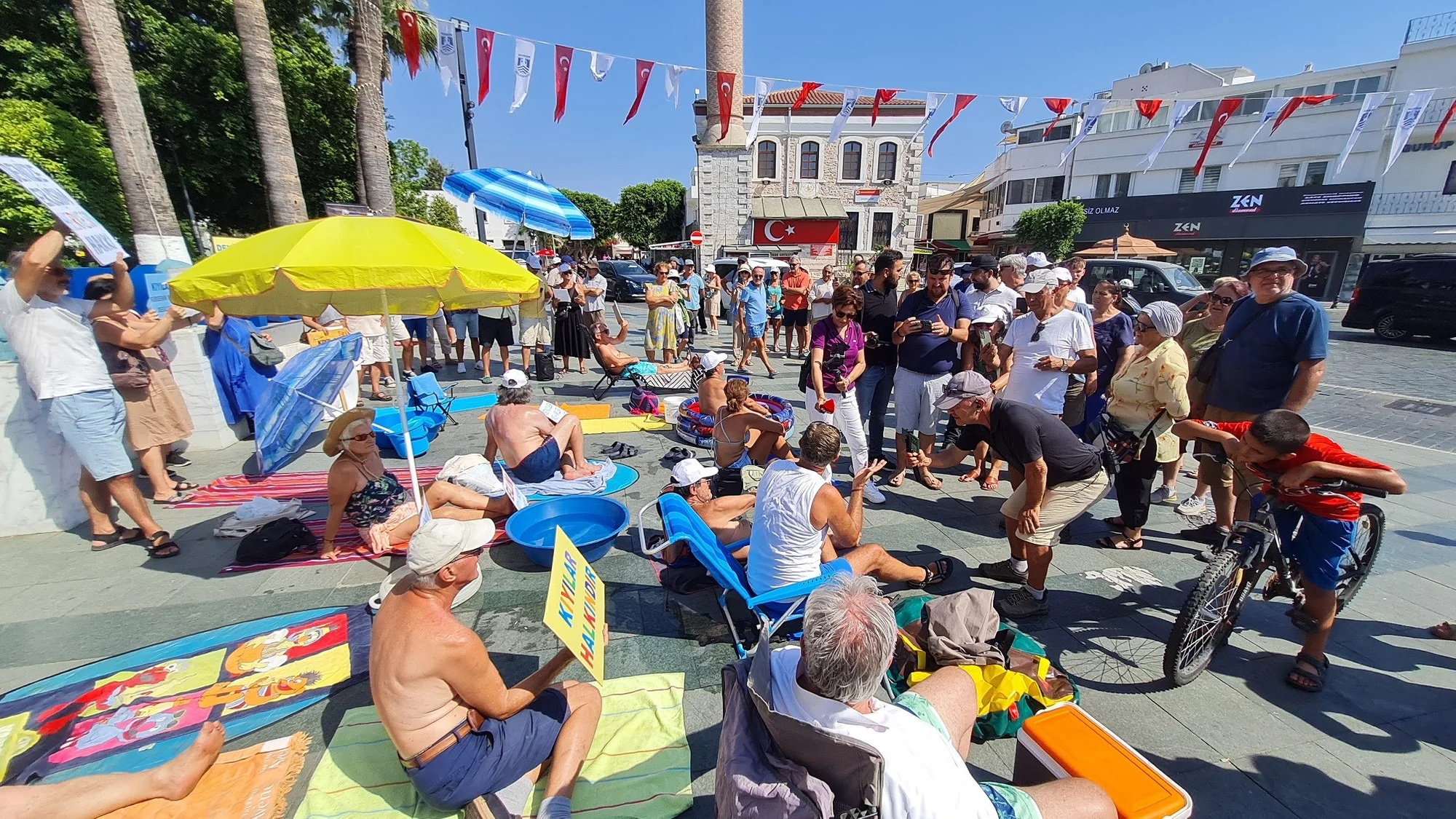 Bodrum’da “Kıyıda yer yok” deyip Belediye Meydanı’nda güneşlendiler
