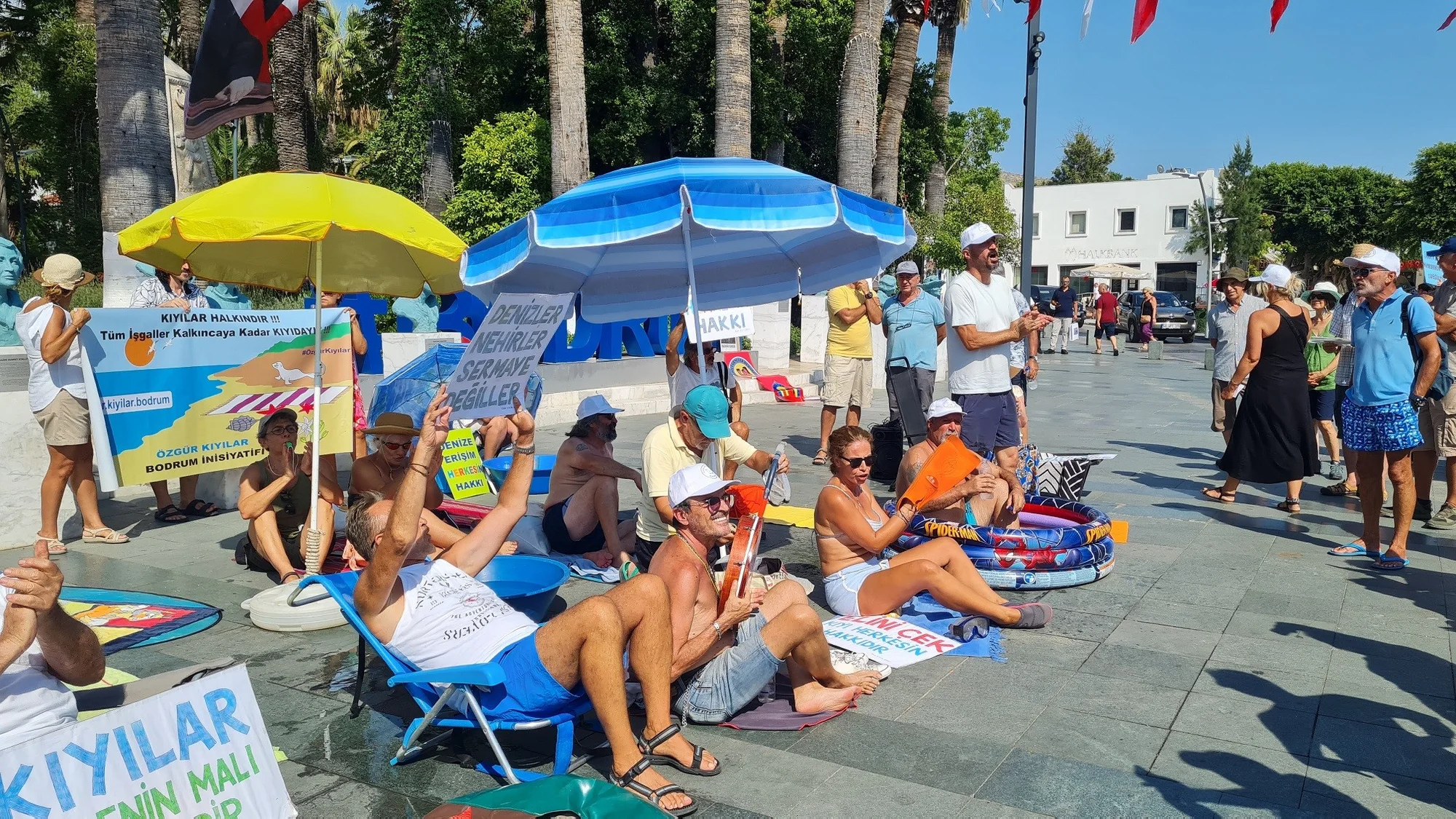 Bodrum’da “Kıyıda yer yok” deyip Belediye Meydanı’nda güneşlendiler